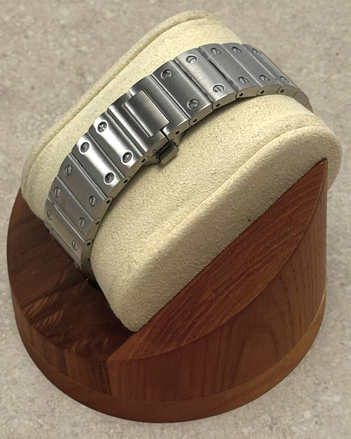 PB TimePiece Aviator watch featuring a stainless steel bracelet with butterfly clasp on a wooden display stand