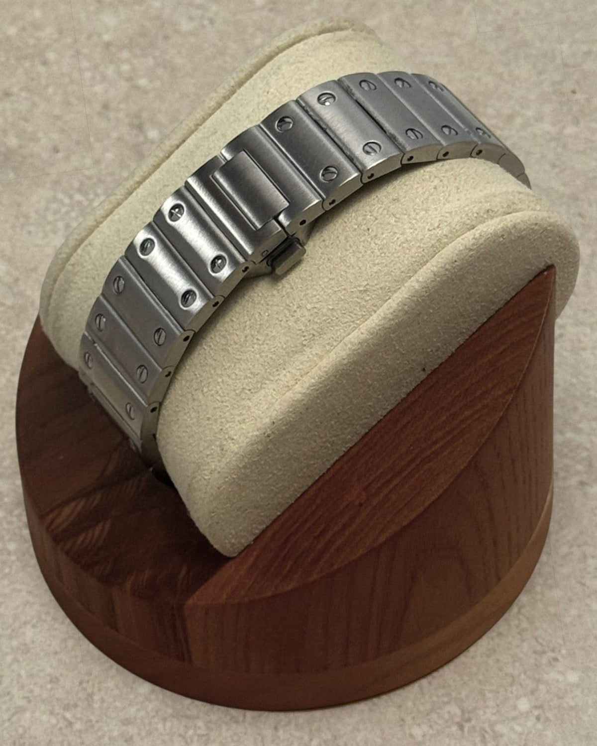 PB TimePiece Aviator watch featuring a stainless steel bracelet with a butterfly clasp on a wooden display stand