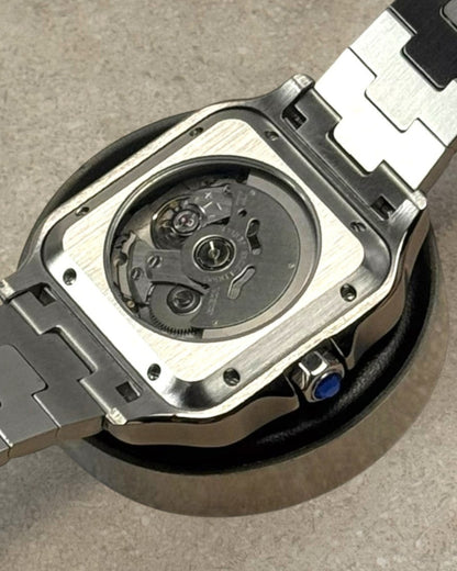PB TimePiece Aviator watch showing the clear case back with automatic movement and stainless steel bracelet