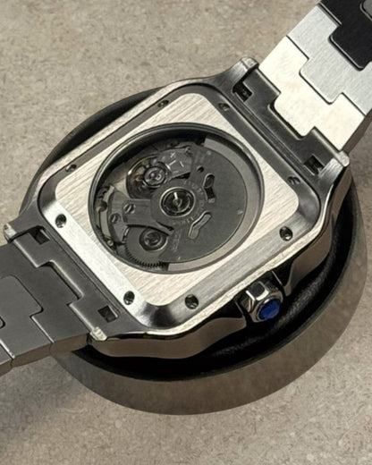 PB TimePiece Aviator watch showing the clear case back with automatic movement and stainless steel bracelet