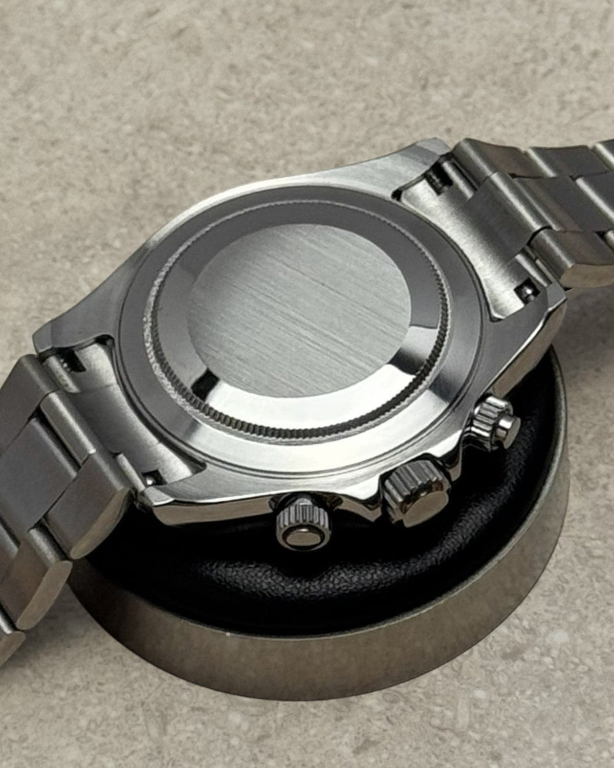 PB TimePiece chronograph watch showing the brushed stainless steel case back and polished oyster bracelet links.