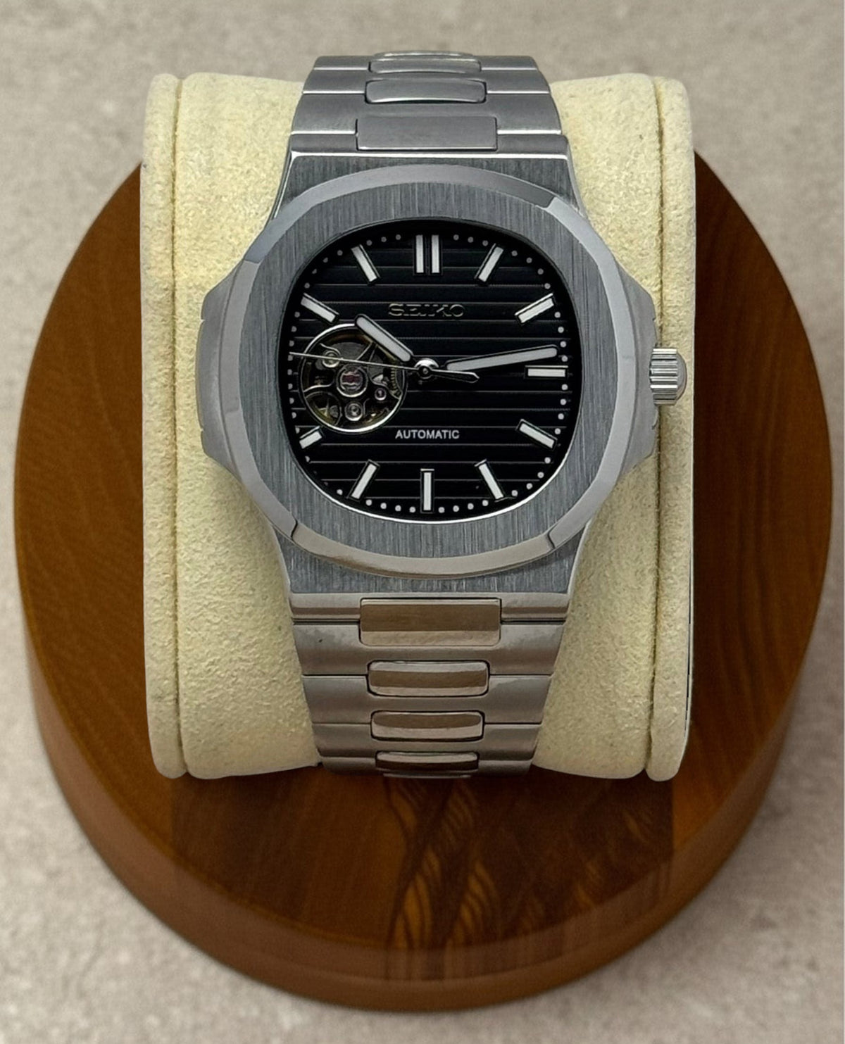 PB TimePiece Novara automatic watch with a black open heart dial, stainless steel case, and nautilus bracelet.