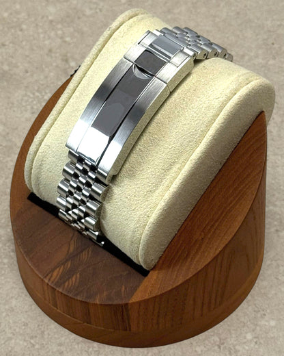 PB TimePiece Submariner Batman watch featuring a stainless steel jubilee bracelet and micro-adjusting clasp on a stand